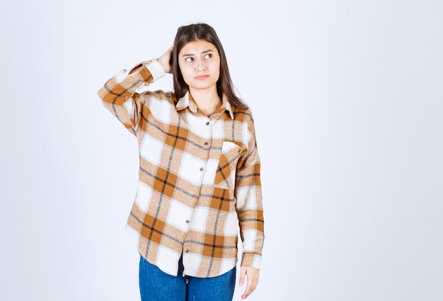 Foto grátis adorável jovem com roupa casual, posando para a câmera e pensando.