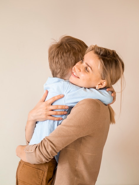 Foto grátis adorável jovem garoto abraçando sua mãe