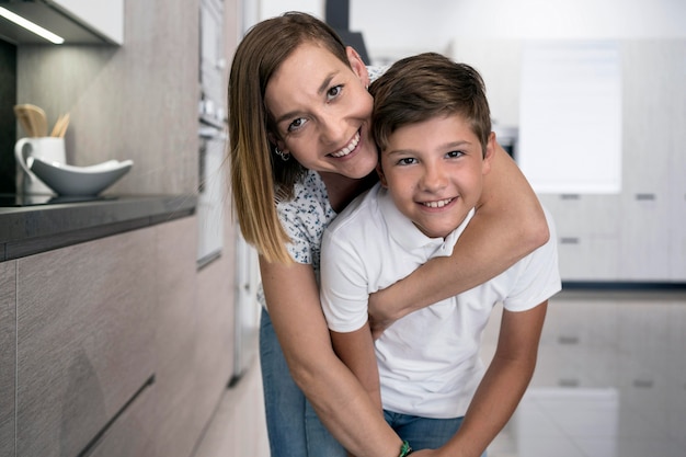 Adorável jovem rapaz posando com a mãe