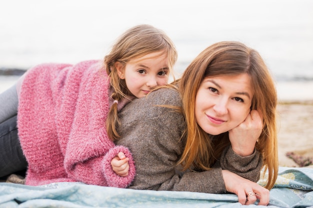 Adorável mãe e filha posando ao ar livre