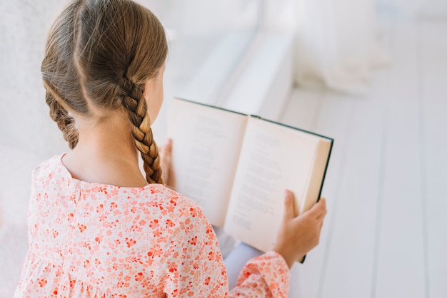 Adorável menina lendo um livro