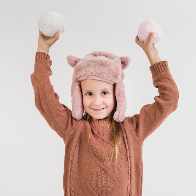 Adorável menina loira segurando bolas de neve