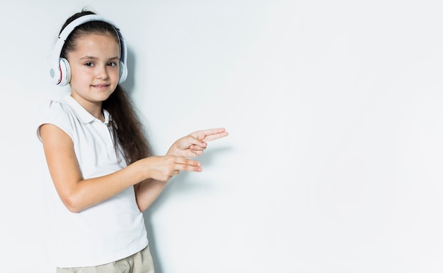 Foto grátis adorável menina ouvindo música com fones de ouvido