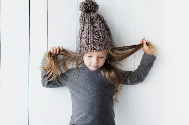 Foto grátis adorável menina posando ao lado de parede branca