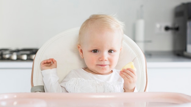 Adorável menina sentada na cadeira de Papa