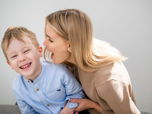 Adorável menino e mãe tocando juntos