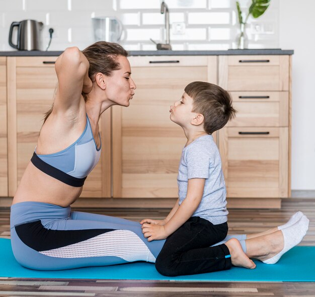 Adorável menino treinando junto com a mãe