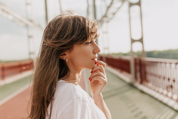 Adorável mulher atraente com cabelo castanho claro em uma ponte