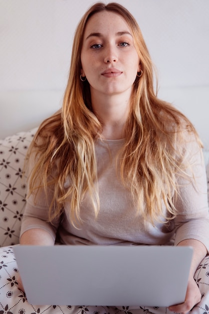 Adorável mulher usando laptop na cama