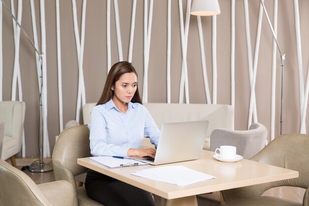 Adulto Empresária de trabalho duro no portátil no café