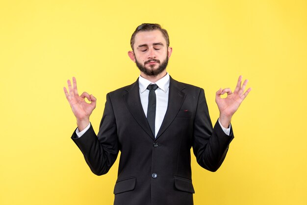 Adulto jovem concentrado fechando os olhos no amarelo