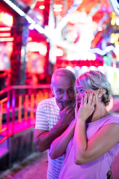 Adultos de tiro médio no parque de diversões