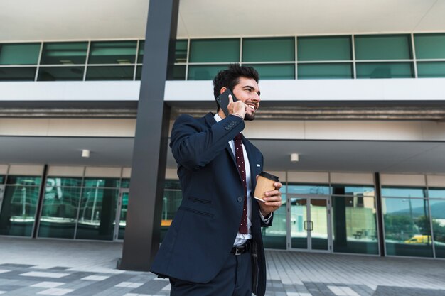 Advogado feliz da vista lateral que fala no telefone ao ar livre