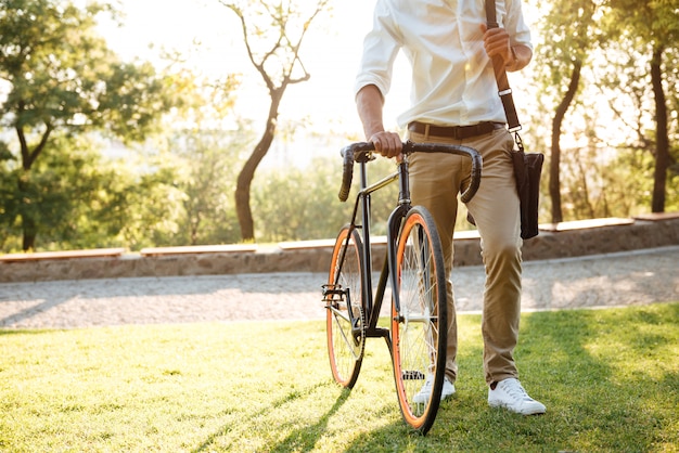 Africano jovem bonito de manhã cedo com bicicleta