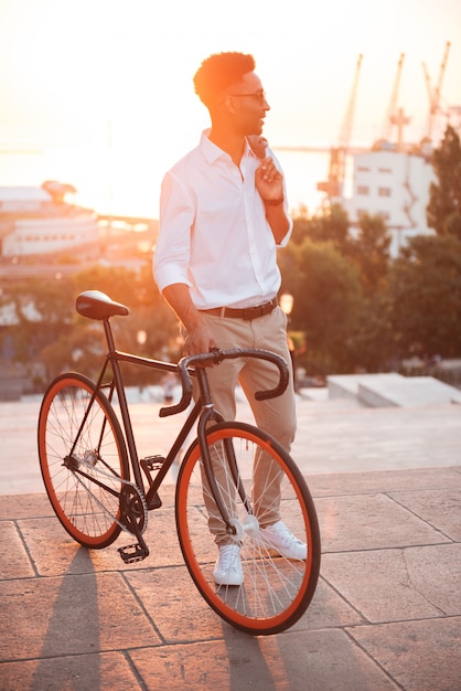 Africano jovem concentrado no início da manhã com bicicleta