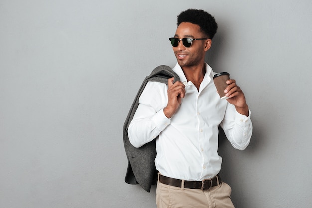 Afro-americano jovem elegante, segurando o casaco por cima do ombro