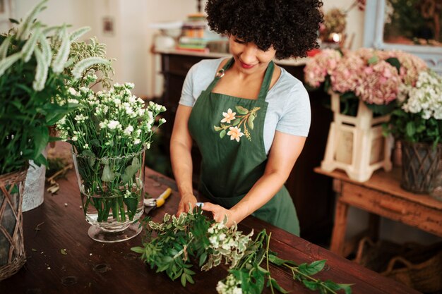 Afro mulher africana, classificação de plantas na mesa de madeira