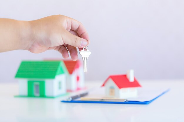 Agente imobiliário com modelo de casa e chaves