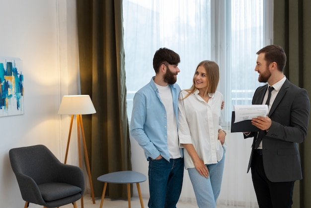 Foto grátis agente imobiliário masculino fazendo negócios e mostrando a casa para um possível casal comprador