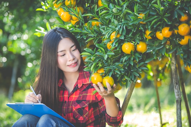 Agricultor de menina laranja segurando o formulário vazio na mão.