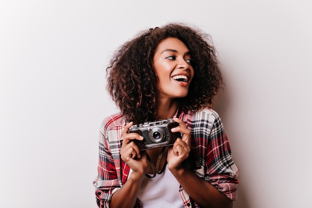 Ainda bem que chillinggrapher feminino. mulher afro-americana sonhadora de camisa quadriculada, segurando a câmera.