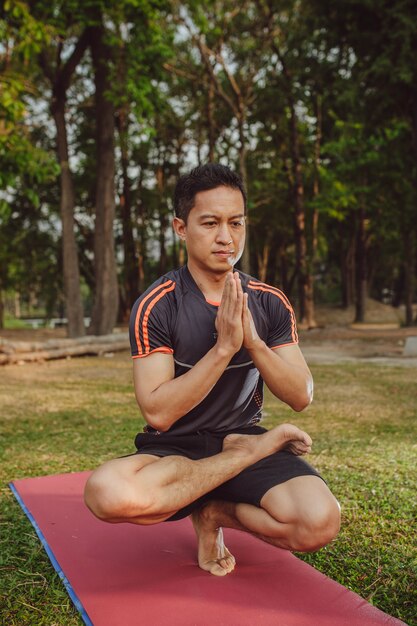 Ajude o homem a fazer yoga no parque