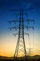 Foto grátis ajuste do sol atrás da silhueta das torres de eletricidade