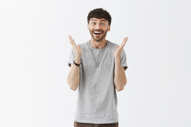 Foto grátis alegre e feliz cara bonito posando contra a parede branca