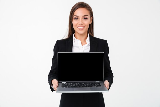 Alegre empresária bonita mostrando a tela do computador portátil