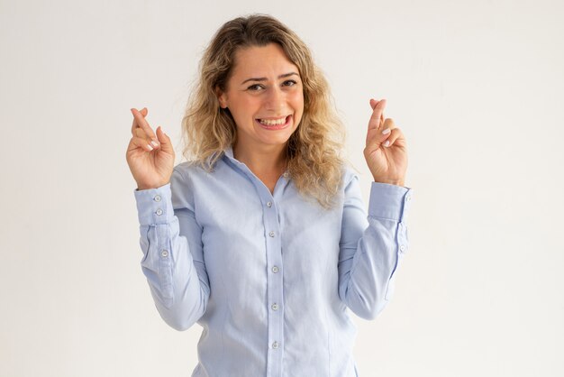 Alegre, excitado, senhora, em, blusa azul, cruzamento, dedos, para, esperança