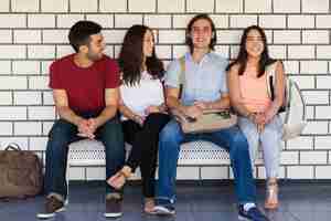 Foto grátis alegre grupo de amigos da faculdade saindo no corredor da escola