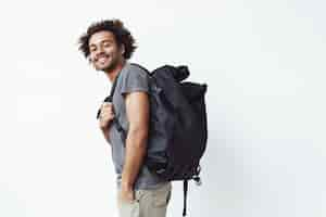 Foto grátis alegre homem africano com mochila sorrindo.