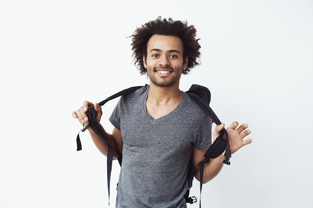 Foto grátis alegre homem africano com mochila sorrindo.