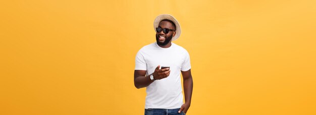Alegre homem afro-americano de camisa branca usando aplicativo de celular feliz hipst de pele escura