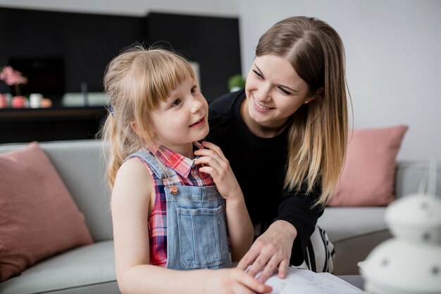 Alegre mãe e filha fazendo lição de casa juntos