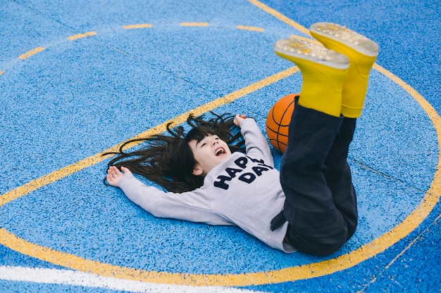 Foto grátis alegre, menina, mentindo, perto, basquetebol, bola