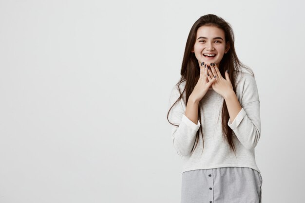 Alegre morena muito charmosa camisola solta com cabelo longo e reto, sorrindo alegremente