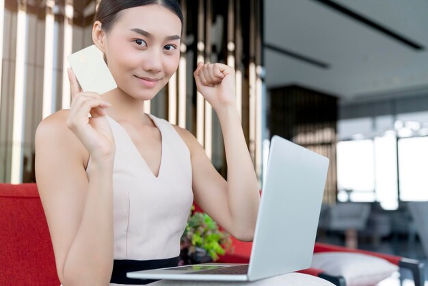 Alegre mulher atraente mulher felicidade alegre mão segure laptop smartphone cartão de crédito compras on-line em casa quarentena branca distanciamento social no surto de propagação do vírus corona covid19