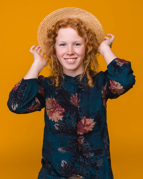 Alegre mulher com cabelo ruivo em estúdio com fundo colorido