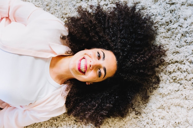 Alegre mulher deitada no tapete