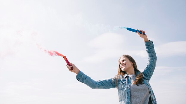 Alegre, mulher segura, fumaça, flares, em, outstretched, mãos