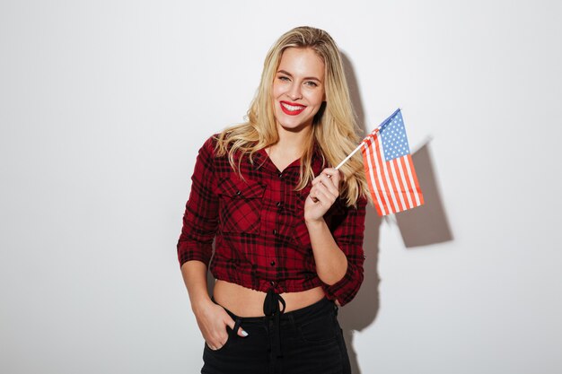 Alegre mulher segurando a bandeira dos EUA.