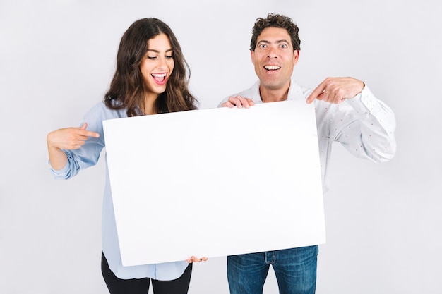 Alegre pai e filha mostrando cartaz vazio