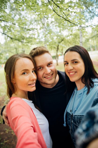 Alegres amigos tomando selfie no parque