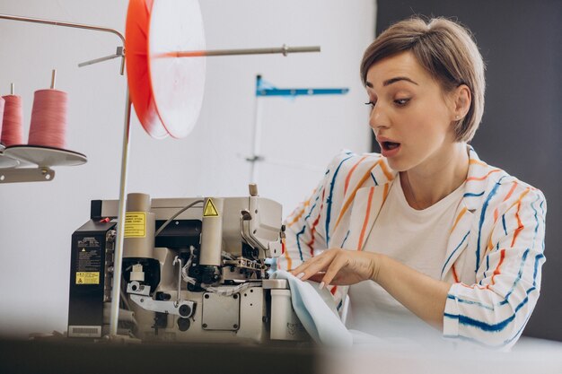 Alfaiate feminina trabalhando com máquina de costura