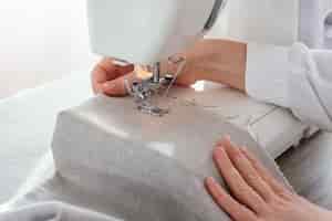 Foto grátis alfaiate feminina trabalhando com máquina de costura