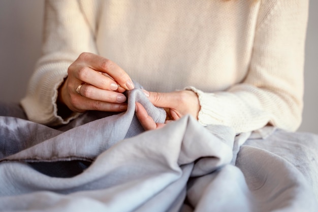 Alfaiate mulher usando agulha e linha para costurar