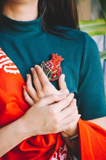 Alfinete de joia em formato de romã na cintura de uma mulher