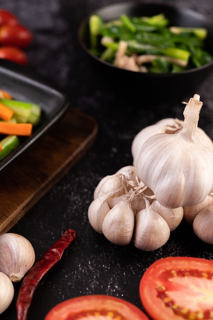 Alho, tomate e garfos para cozinhar. Foco seletivo.