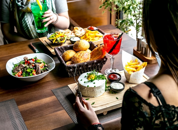 Almoço conjunto com salada pratos principais pão e bebidas vista lateral